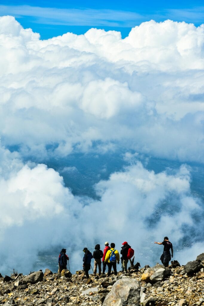 A group of hikers trek above the clouds on a mountain in Central Java, Indonesia.