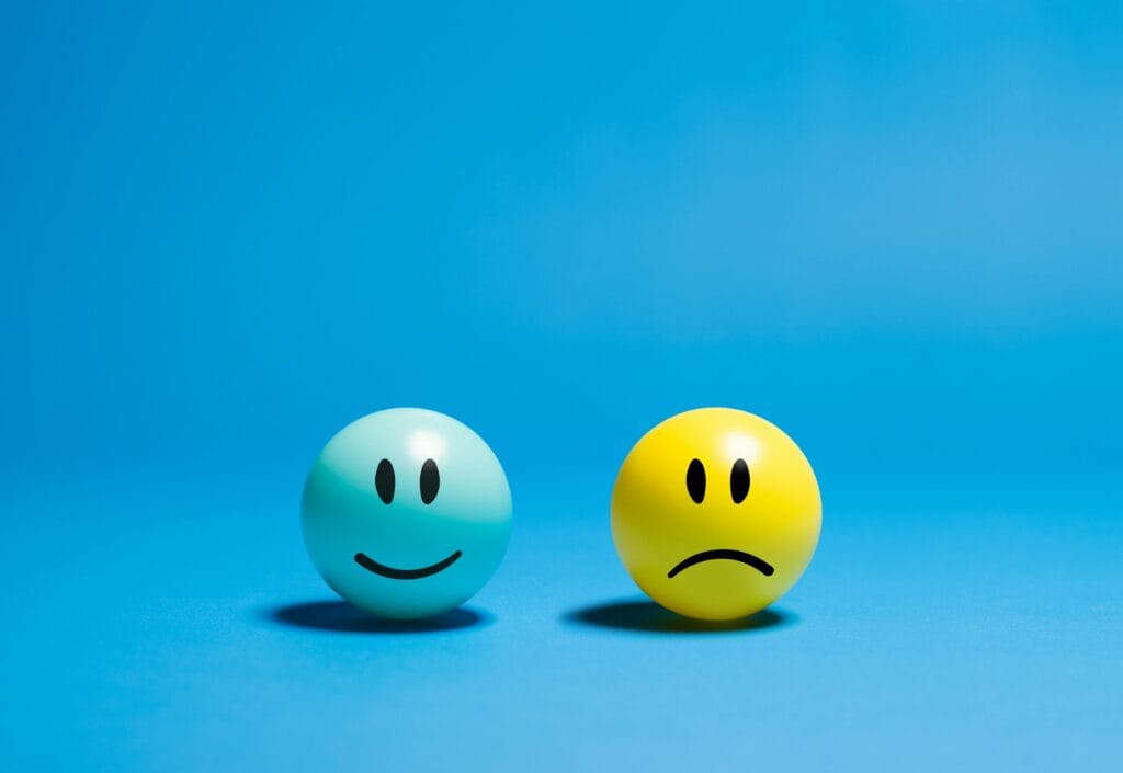 Two smiley balls representing opposite emotions psychology trends 2026: AI chatbots, digital burnout, loneliness epidemic & social media’s hidden mental health effects