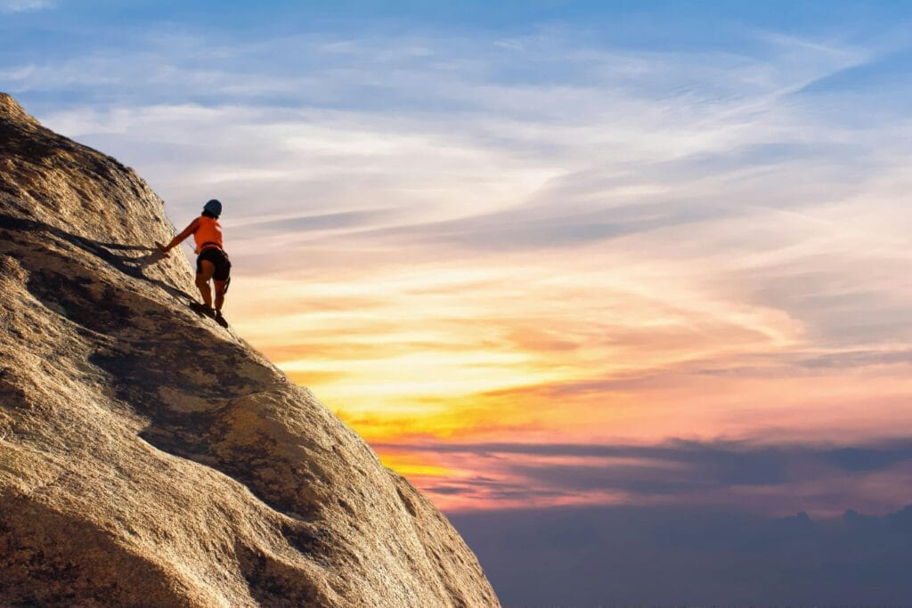 Climber conquers rock face at sunset, embracing the thrill and challenge in this way he is conquering fear of heights in technical rock climbing