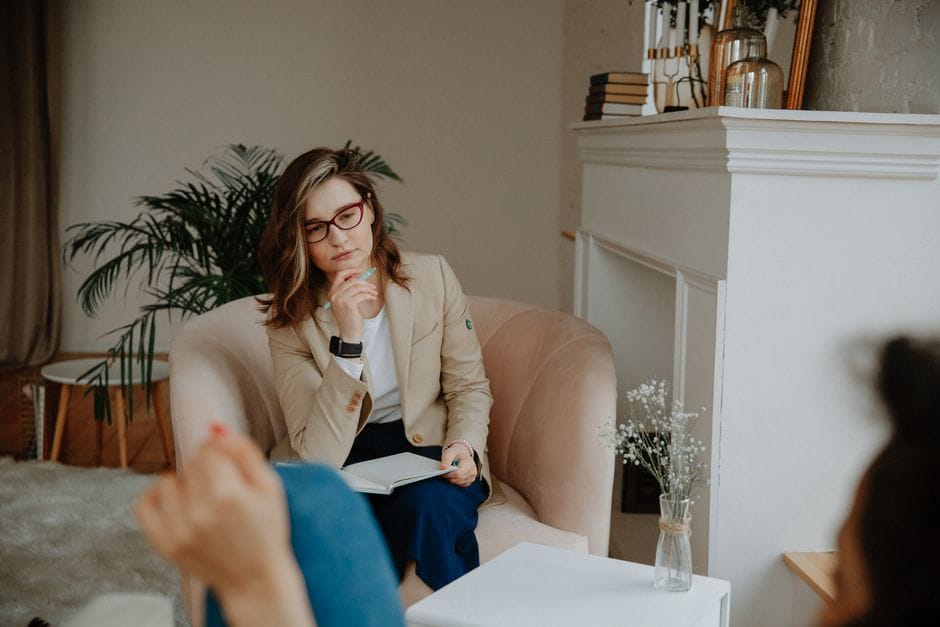 A licensed financial therapist guiding a client through mindset exercises focused on overcoming anxiety about net wealth.