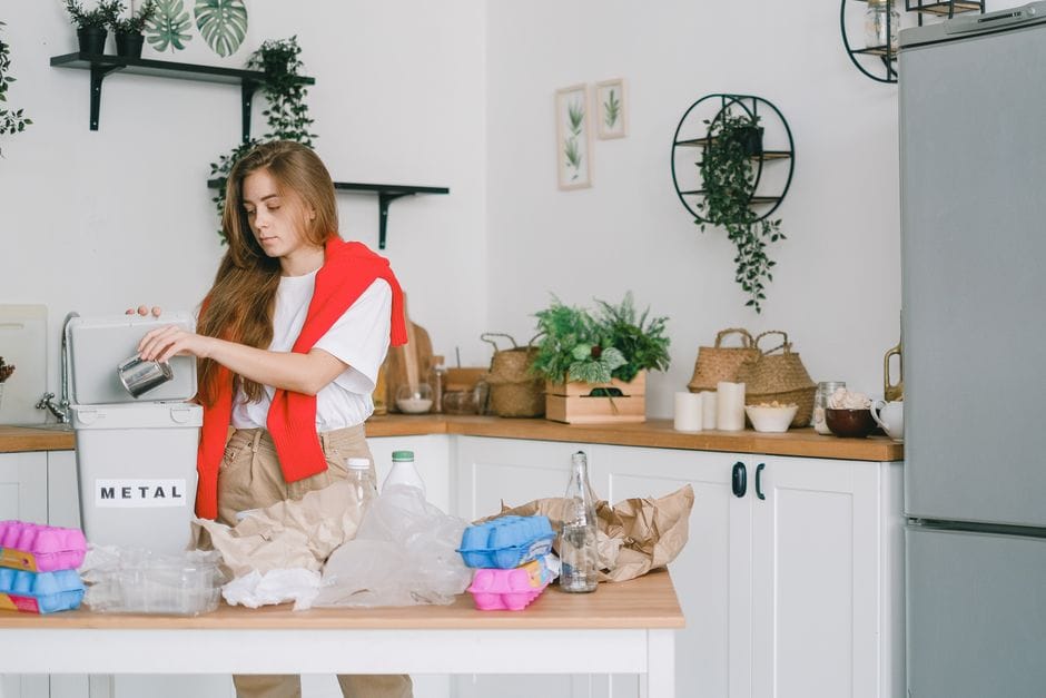 A flatlay of reusable items and a planner displaying simple ways to live more sustainably everyday.